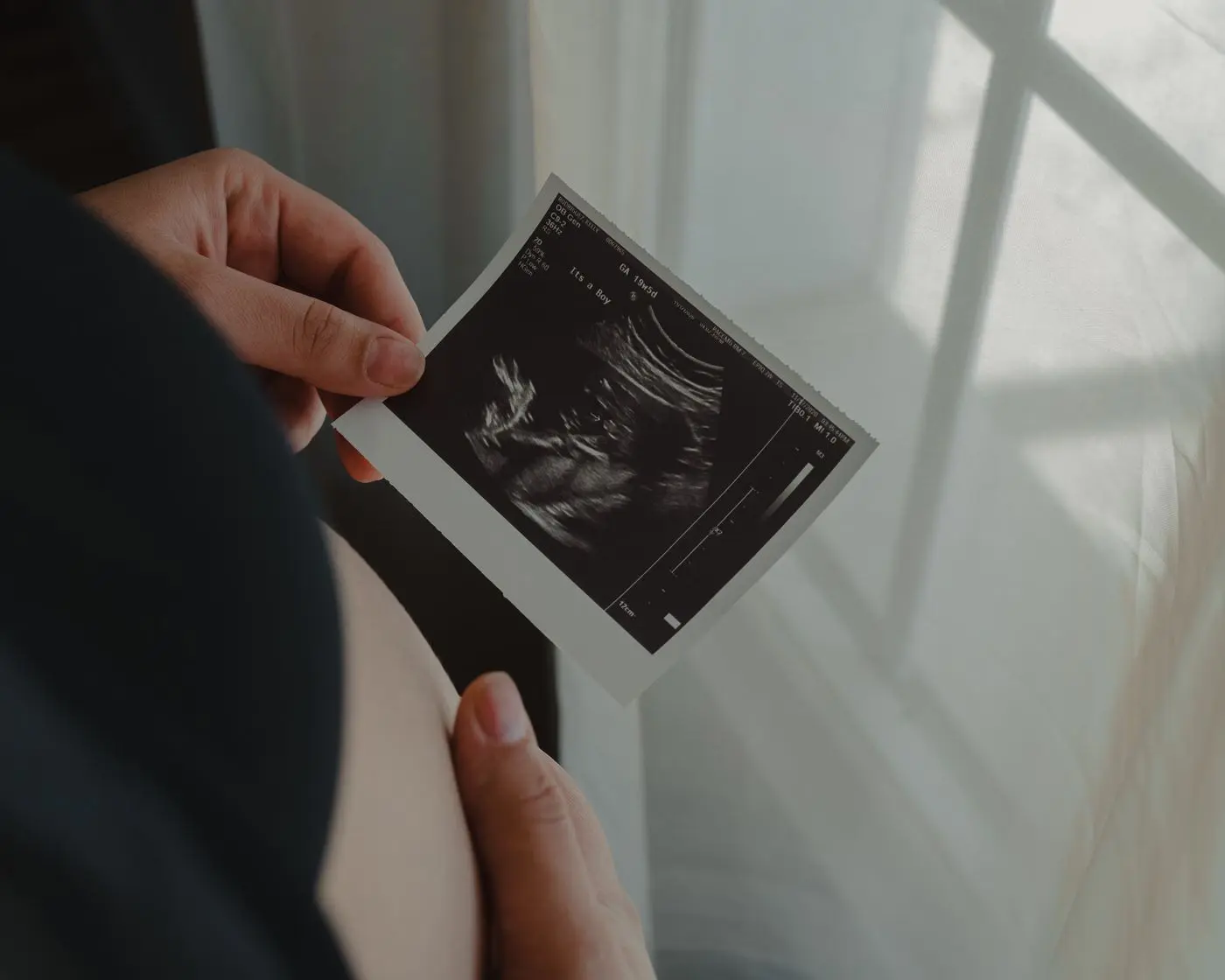 Expecting mother holding an ultrasound photo